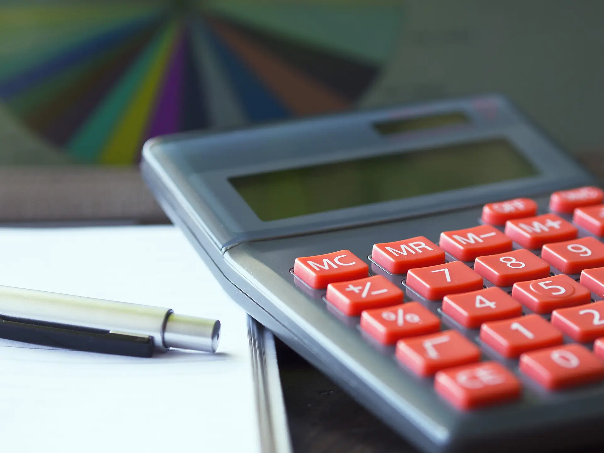 Calculator and pen on desk, illustrating the process of filing a car insurance claim in Illinois