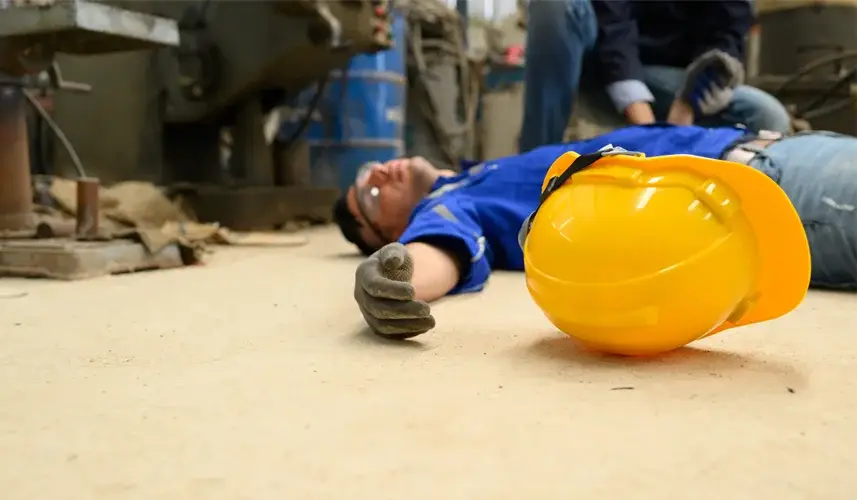 a man on the floor from an accident at factory. you can call an injury lawyer for an legal overview