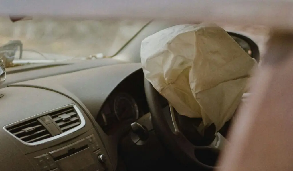 Dashboard of a Honda vehicle with an inflated airbag, emphasizing the importance of the Honda Airbag Recall 2024 and the need for a honda airbag recall check.