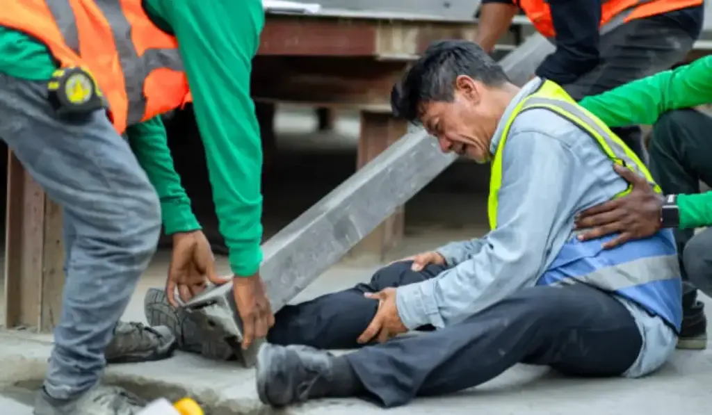 Injured construction worker receiving assistance after an accident on-site in Chicago, highlighting the risks of construction accidents and the need for legal support.